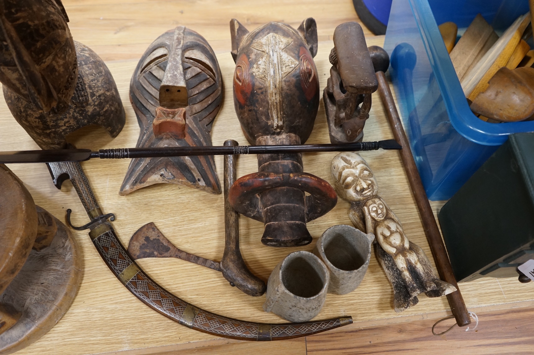 An eclectic group of tribal carvings to include a stool, various weapons, masks, etc, largest mask 52cm high